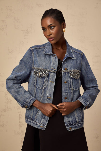A light blue denim jacket adorned with sparkling rhinestones featuring a feminine and glamorous design
