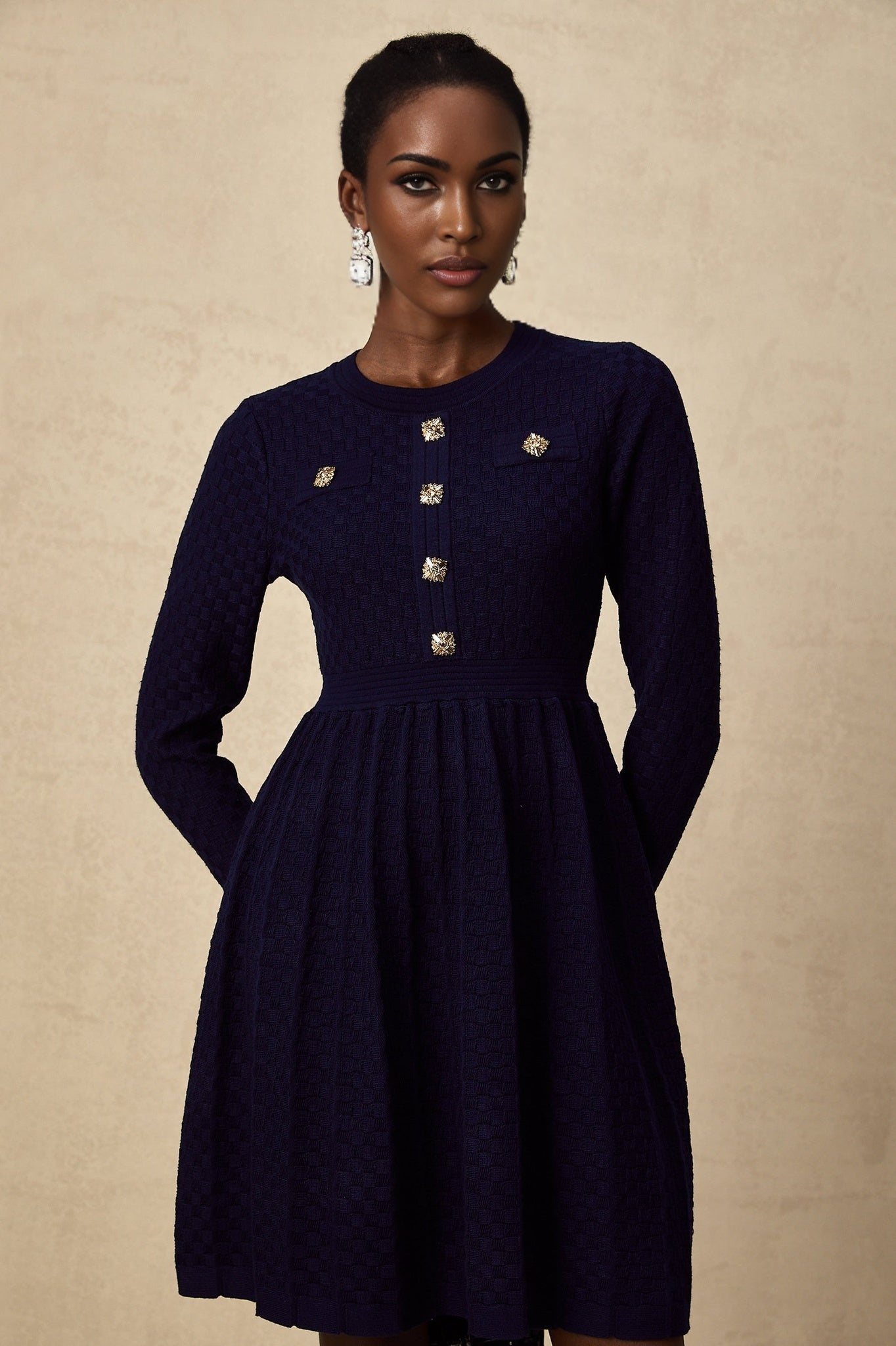 A navy blue mini dress with a basket weave texture and short length featuring a fitted silhouette and sleeveless design
