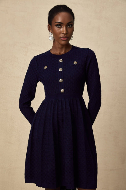 A navy blue mini dress with a basket weave texture and short length featuring a fitted silhouette and sleeveless design