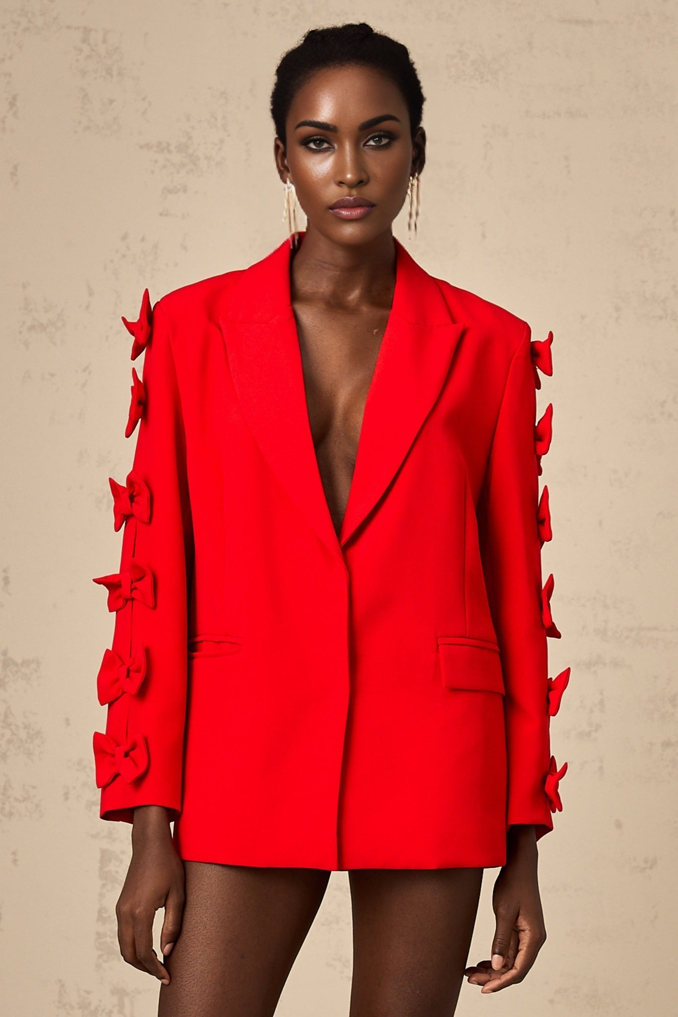 A red blazer with a bow detail and cutout design featuring a tailored fit and feminine silhouette