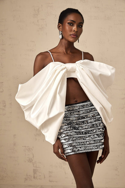 White sleeveless top with scoop back and decorative bow detail