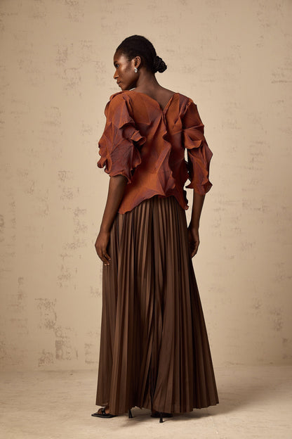 Woman wearing a demi brown matching set with creased top and skirt