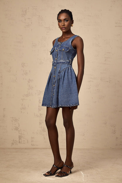 Woman wearing short blue denim dress with belt cinched at waist