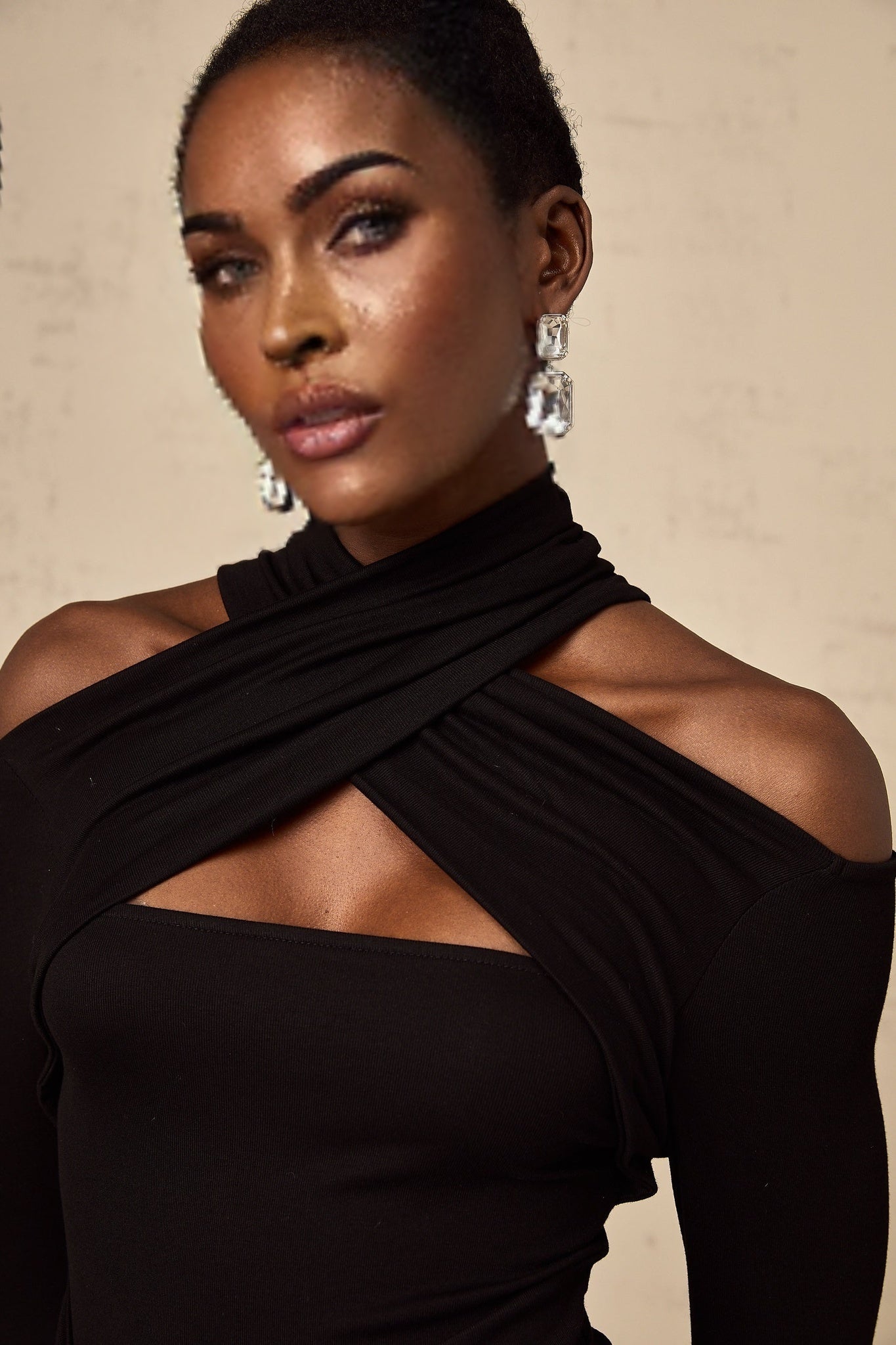 A black sleeveless top with ruched detailing made from stretchy jersey fabric