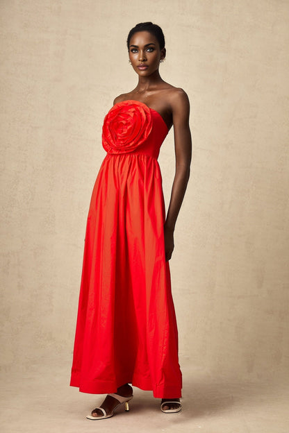 A red maxi dress with ruffled 3d petal details covering the bodice and skirt creating texture and visual interest