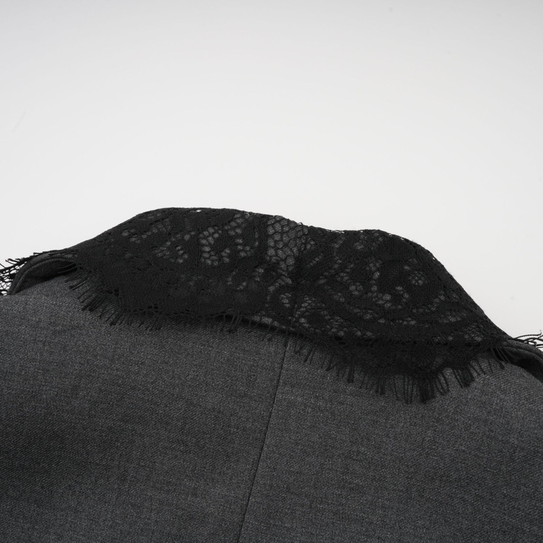 Woman wearing grey blazer with lace panel details on sleeves and back