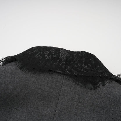 Woman wearing grey blazer with lace panel details on sleeves and back