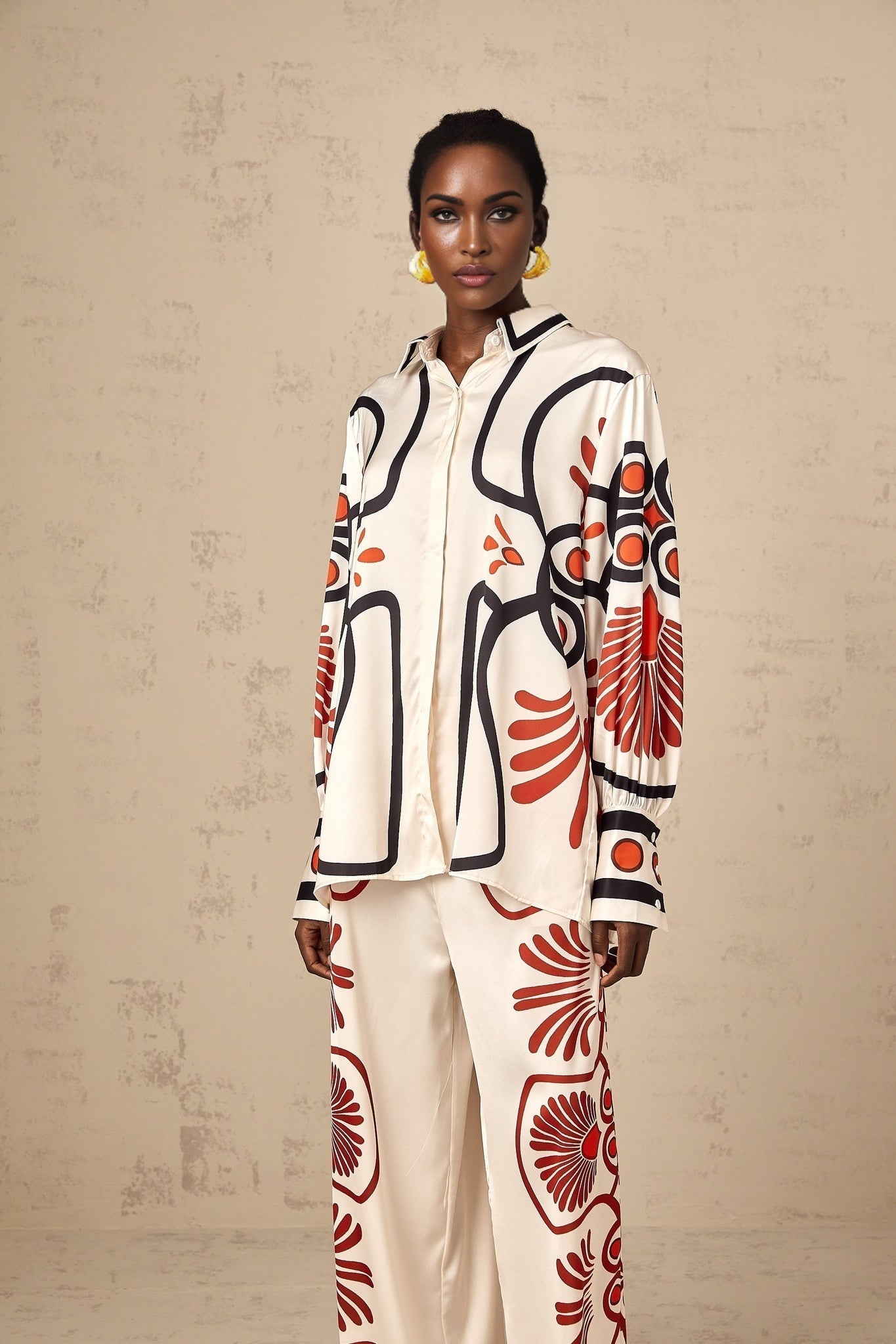 Woman wearing a matching set of shirt and trousers with colorful graphic print pattern