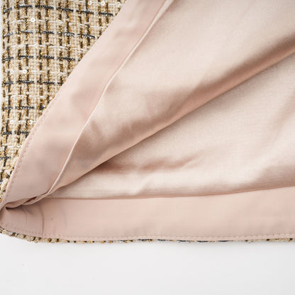 A gold tweed jacket and matching skirt set with sequin embellishments