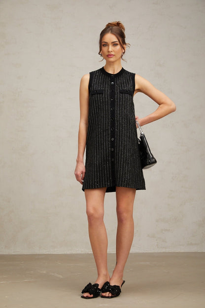 A black mini dress with vertical stripes made of sequins and knit fabric featuring a Zelda design