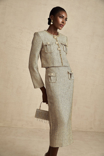 A gold colored tweed jacket and matching skirt set with sequin embellishments The outfit has a luxurious and festive appearance suitable for formal occasions