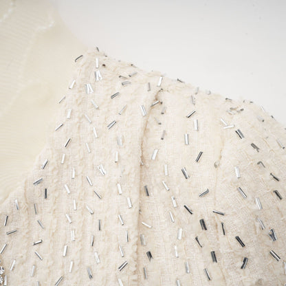 White cropped jacket with beaded details and ruffle trim