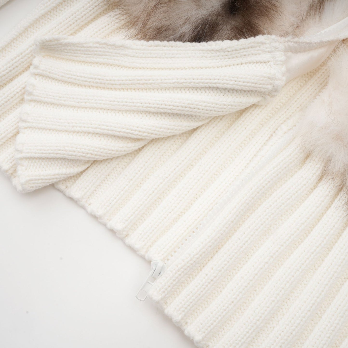 A tan colored faux fur jacket with ribbed knit detailing and a cozy oversized fit