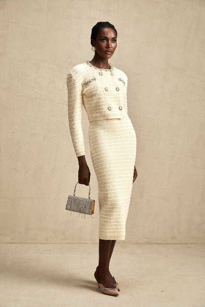A matching set consisting of a knit cardigan and skirt both embellished with decorative details named Justine The cardigan and skirt are coordinated in style and color creating a cohesive outfit