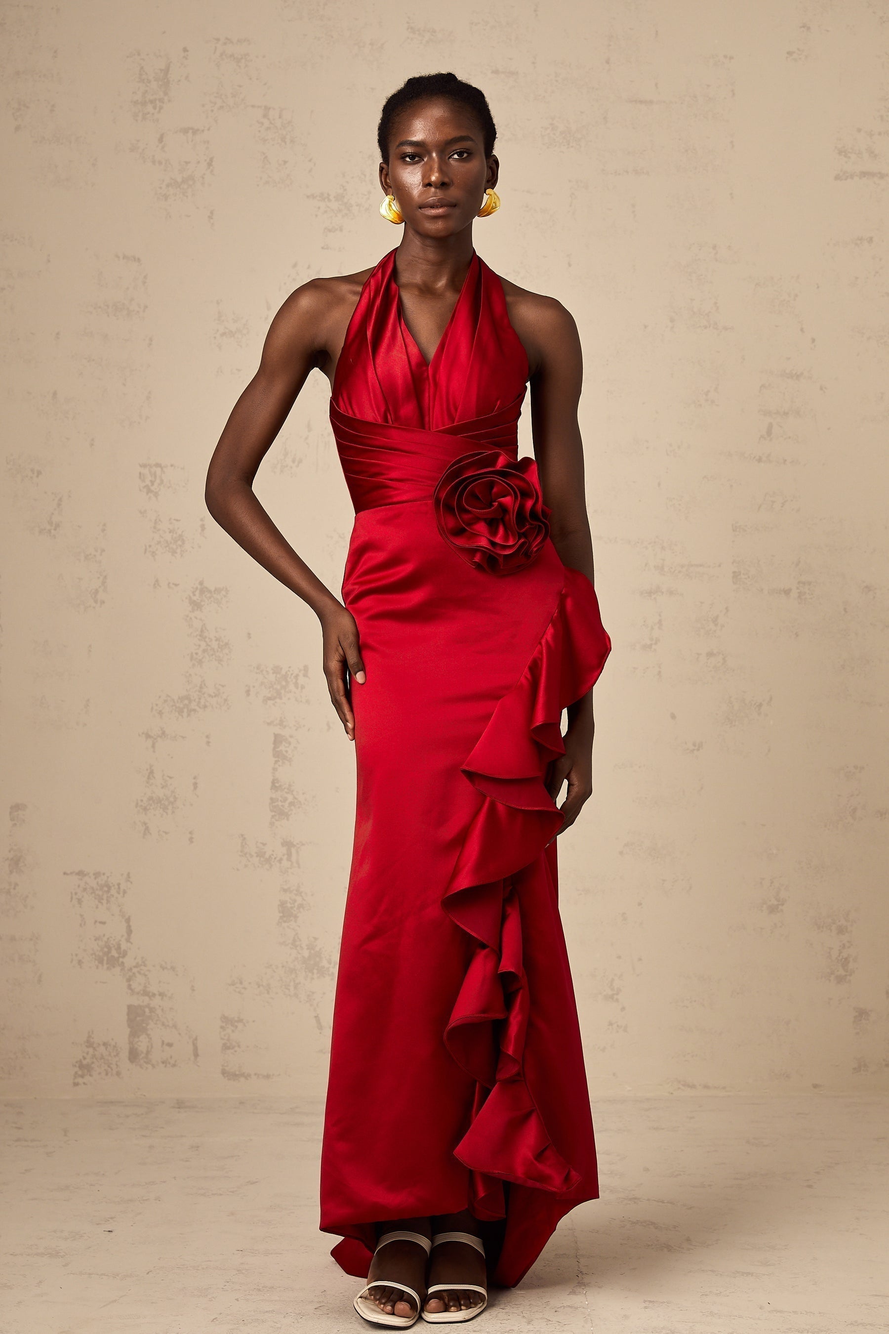 A red halterneck maxi dress featuring 3D petal ruffles and a flowing long skirt