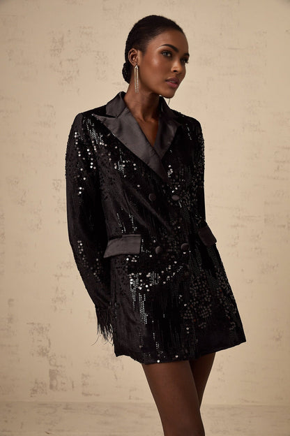 Woman wearing black blazer with feather trim and sequin embellishments