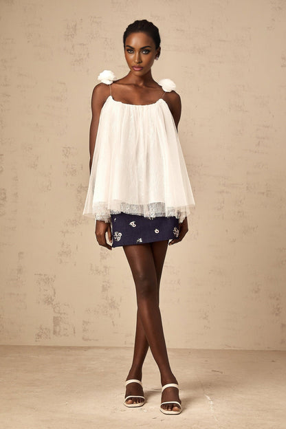 White sleeveless top with floral mesh overlay and flower appliques
