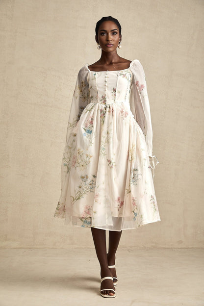 A woman wearing a floral print midi dress with a square neckline named Anne