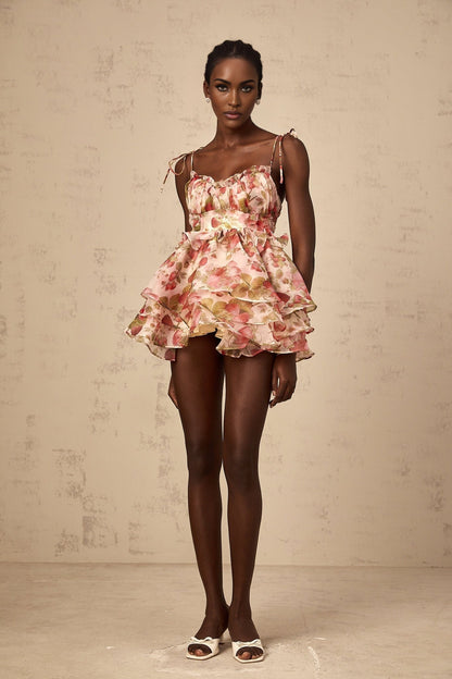 A tiered mini dress with a strawberry print pattern featuring a design inspired by Angele