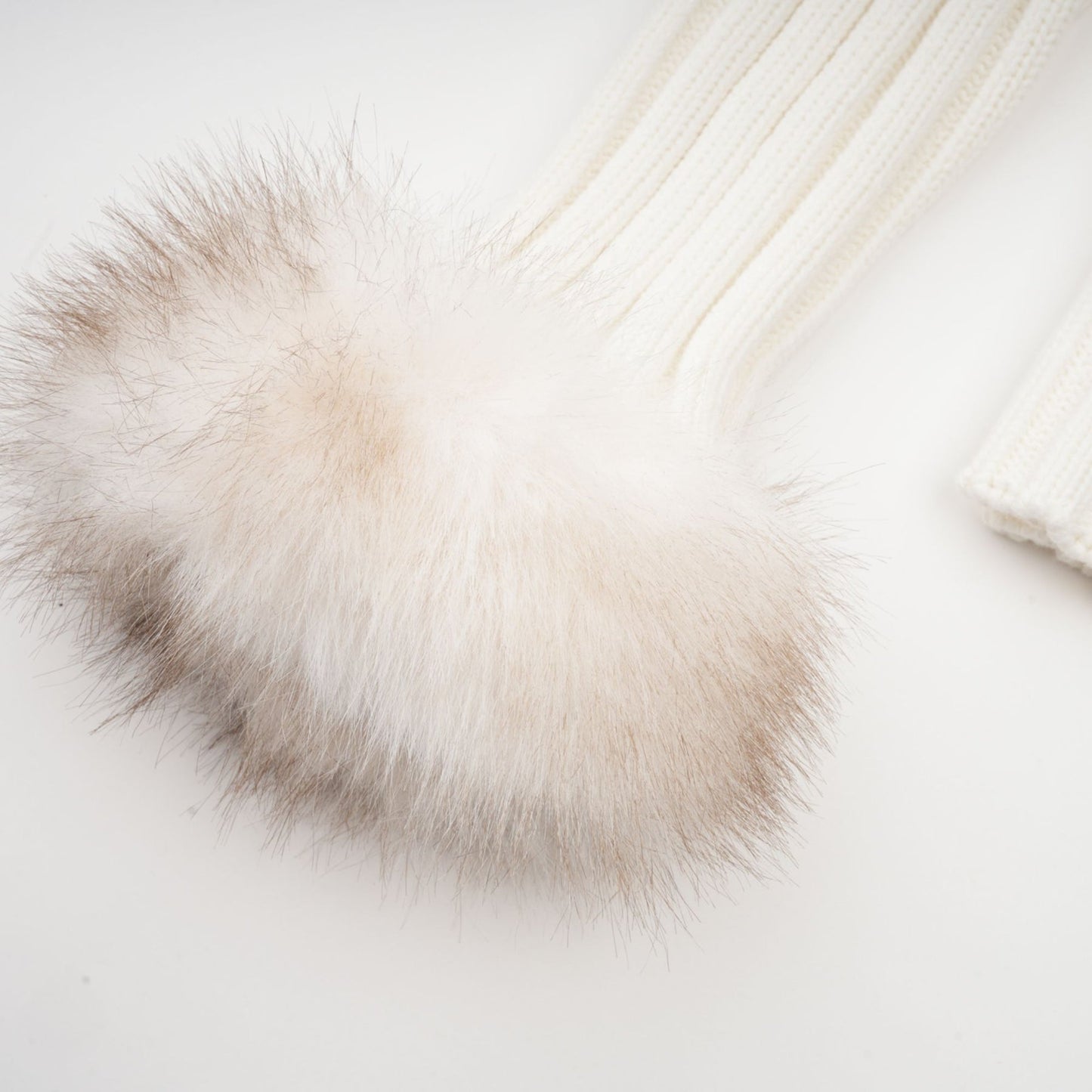 Woman wearing a plush faux fur jacket with ribbed knit details in light beige color