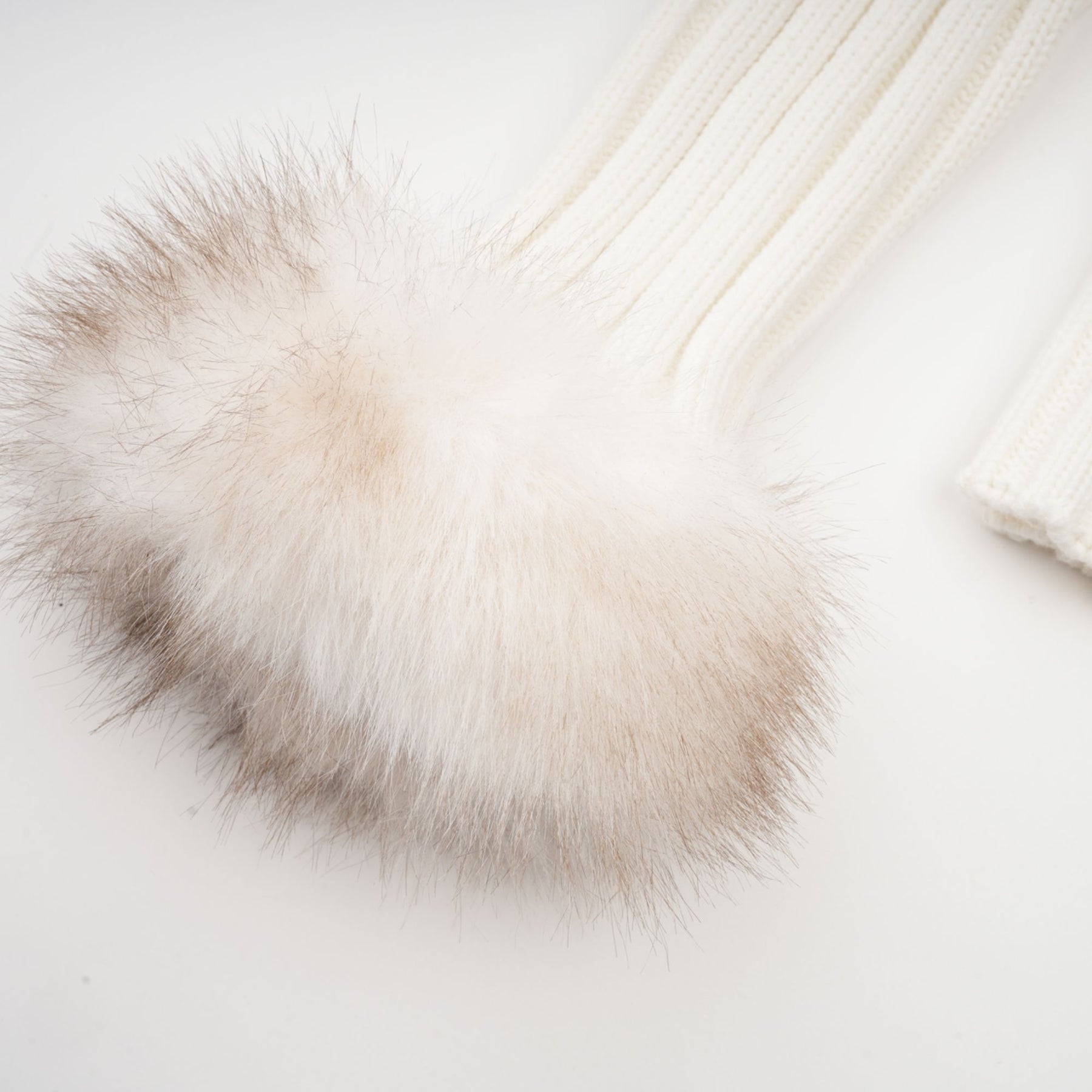 Woman wearing a plush faux fur jacket with ribbed knit details in light beige color