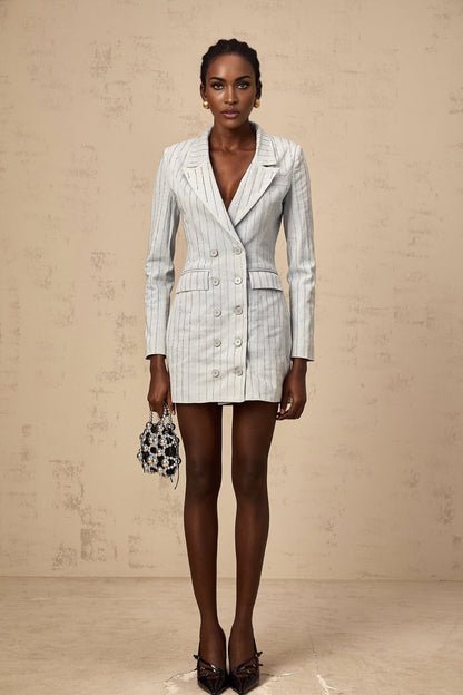 Woman wearing blue denim mini dress with rhinestone embellishments and blazer style collar and lapels