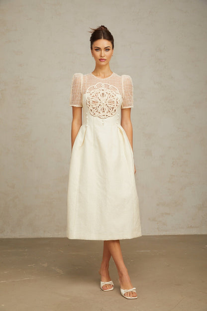 A white midi dress with braided panelling and a fitted silhouette