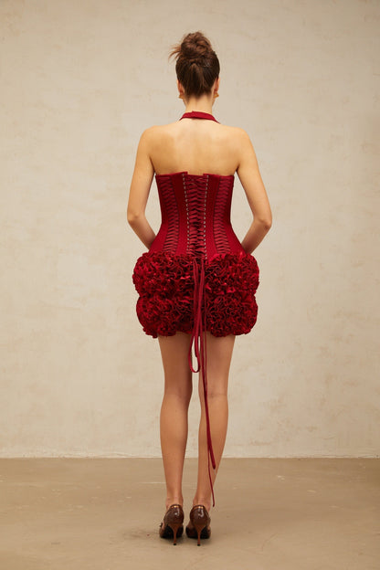 Woman wearing bright red halterneck top with laceup detail at front