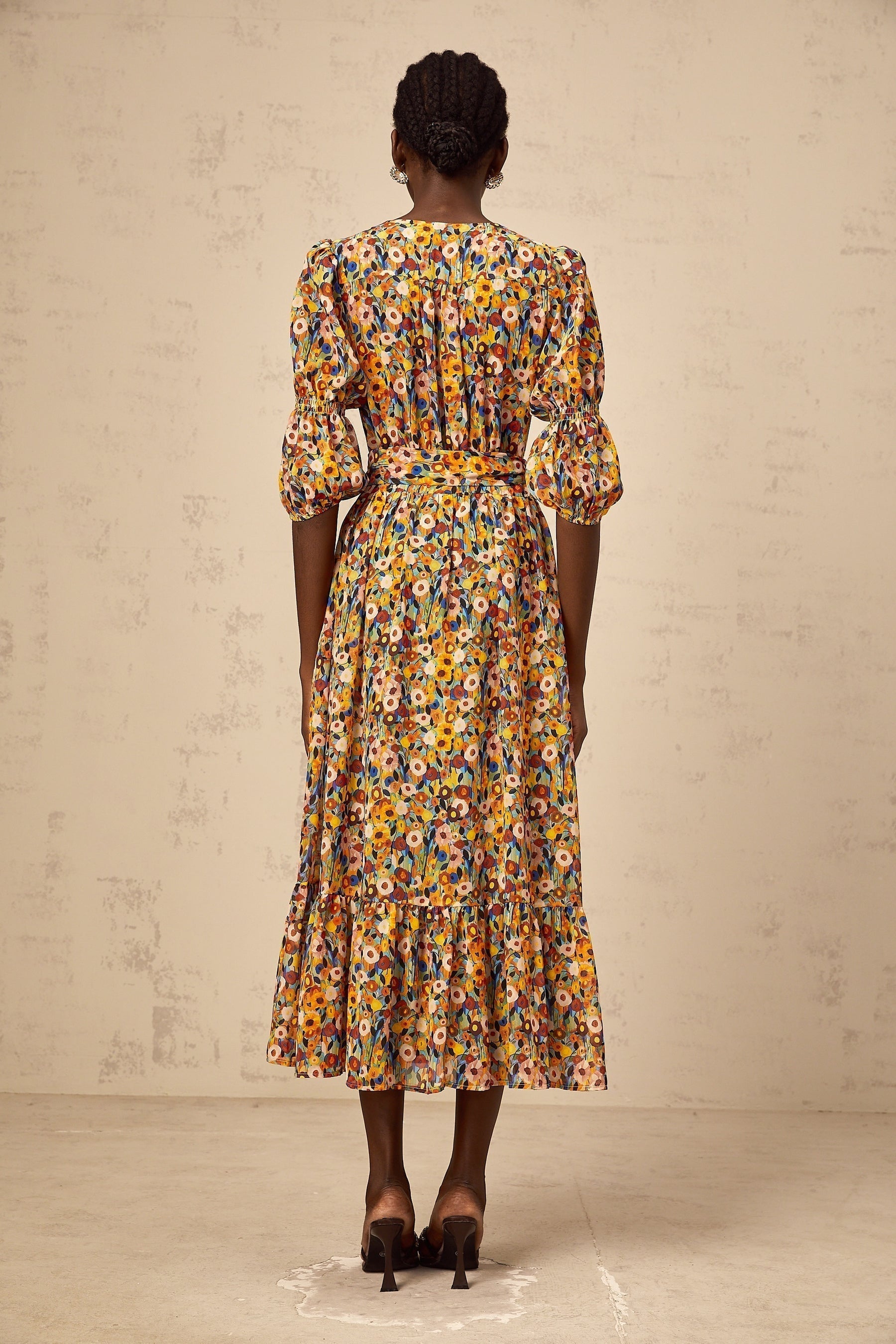 A yellow midi dress with a floral print pattern and Vneck design named Éliane