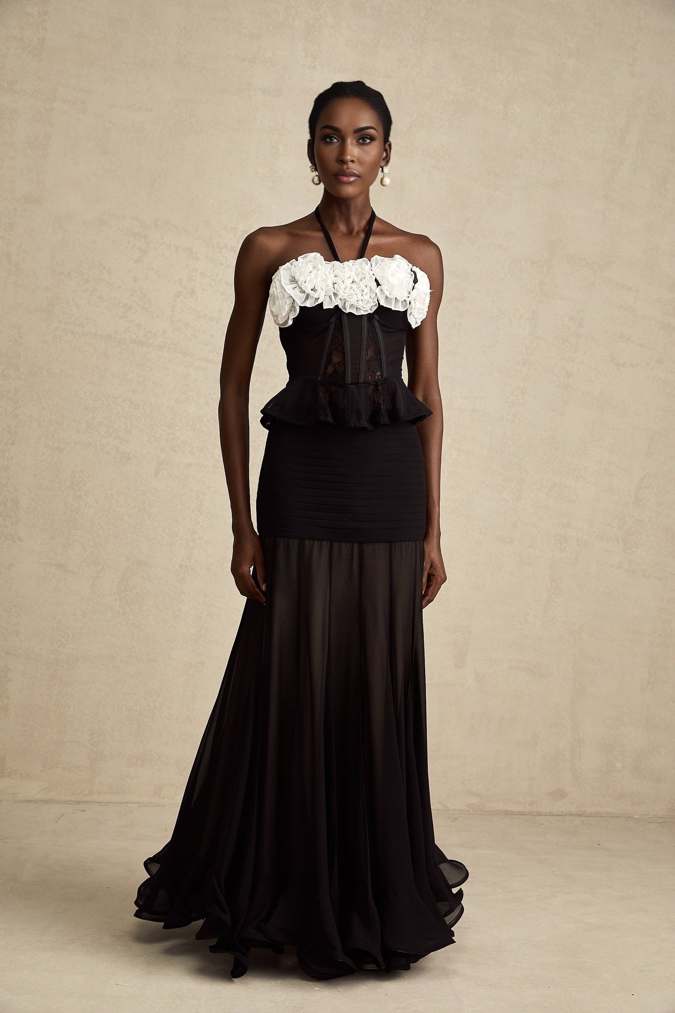A black corset top with faux flower lace detailing featuring a structured bodice and intricate floral pattern