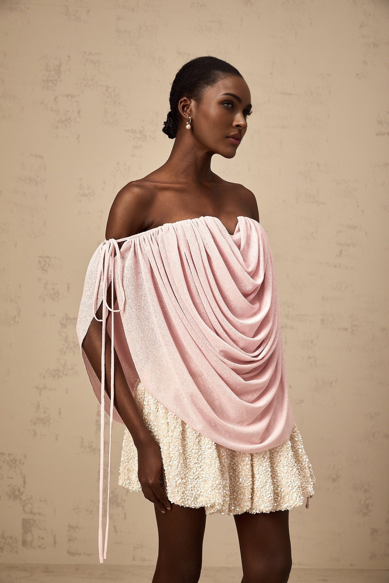 A pink offshoulder top with ruched detailing called Quintina worn by a model against a plain background