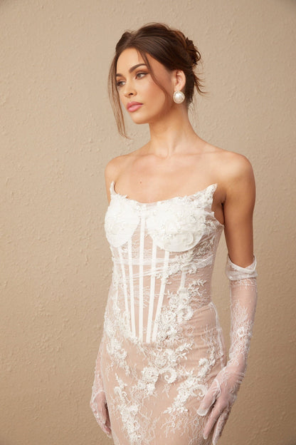 A long white tulle maxi dress with a corset bodice featuring colorful floral embroidery throughout the dress