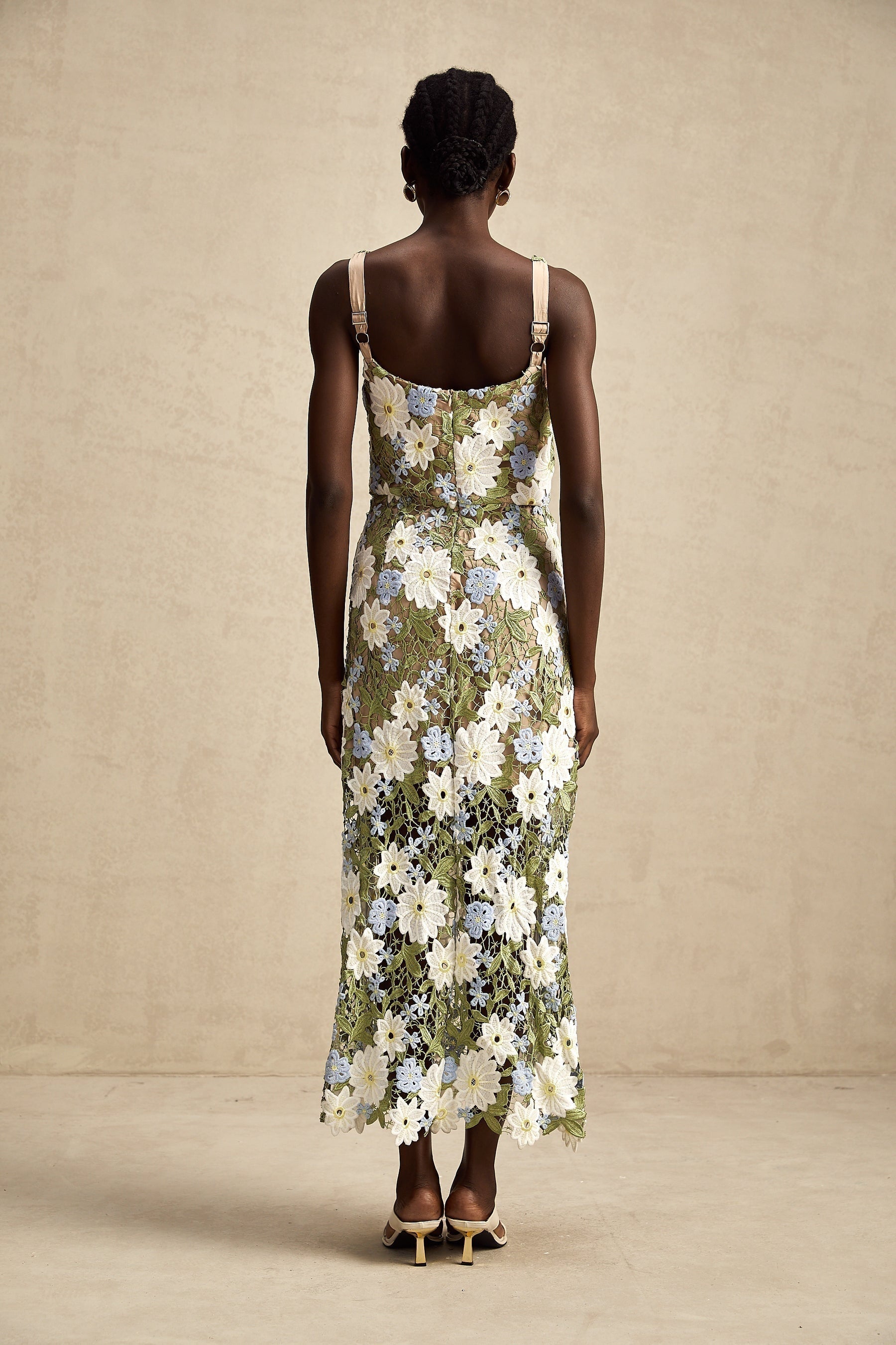 Woman wearing a white midi dress with floral embroidery and cutout details