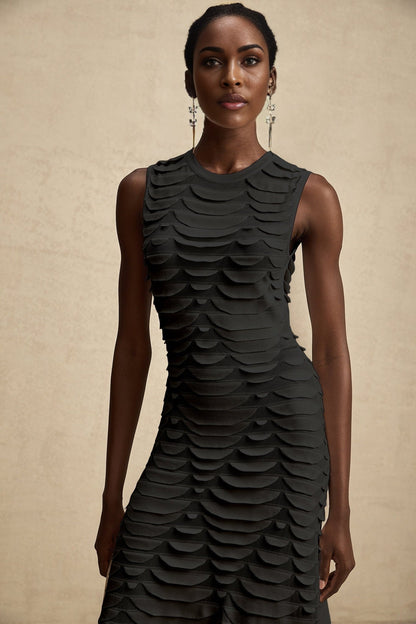 A woman wearing a midi length dress with a snake pattern print and godet inserts for a flared silhouette