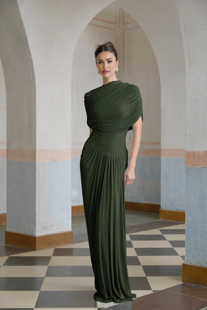 A green asymmetric maxi dress with pleats worn by a model standing against a plain background