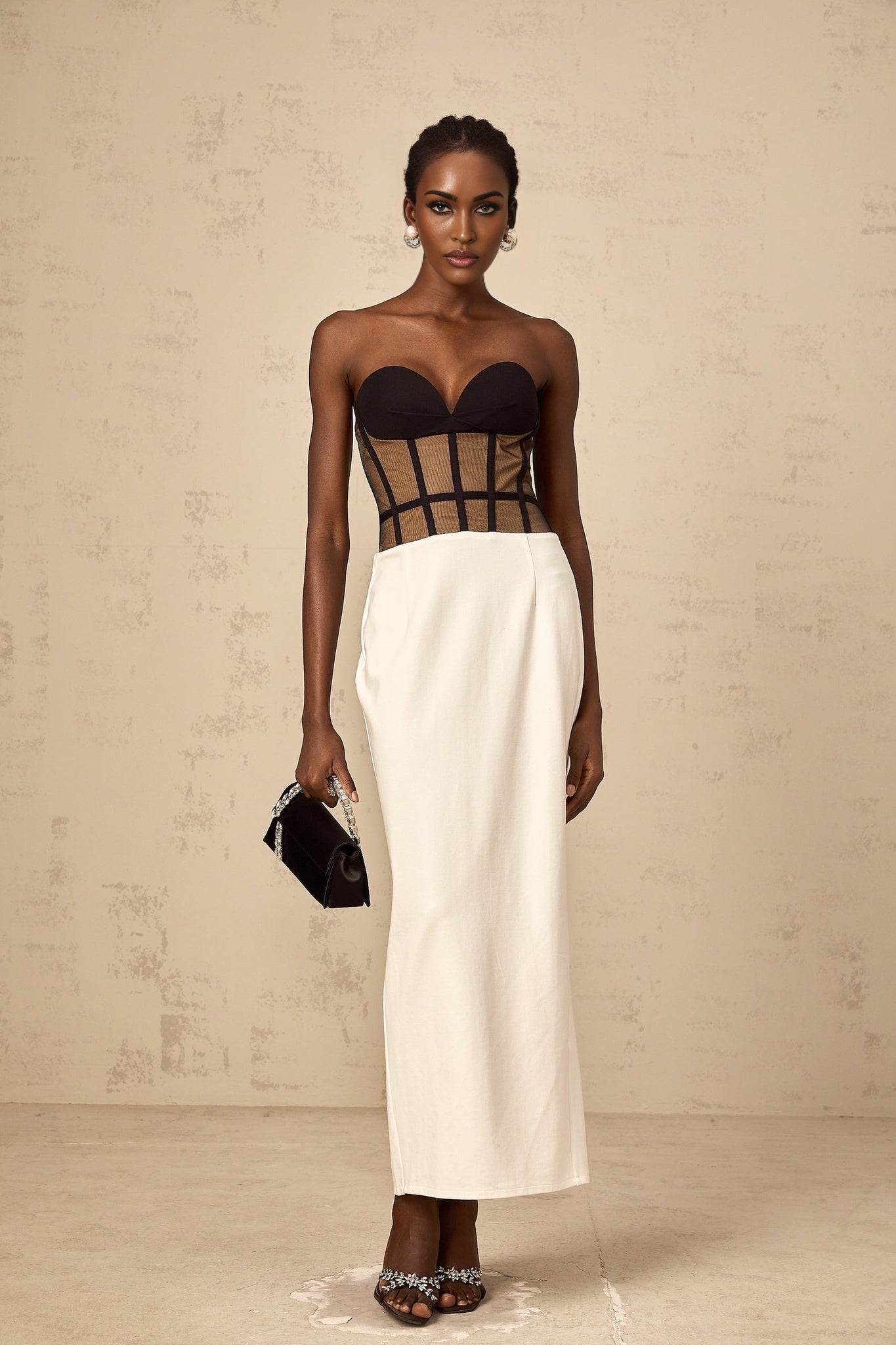 Woman wearing long sheer maxi dress with contrasting corset bodice and flowing skirt