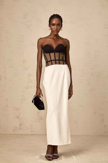Woman wearing long sheer maxi dress with contrasting corset bodice and flowing skirt