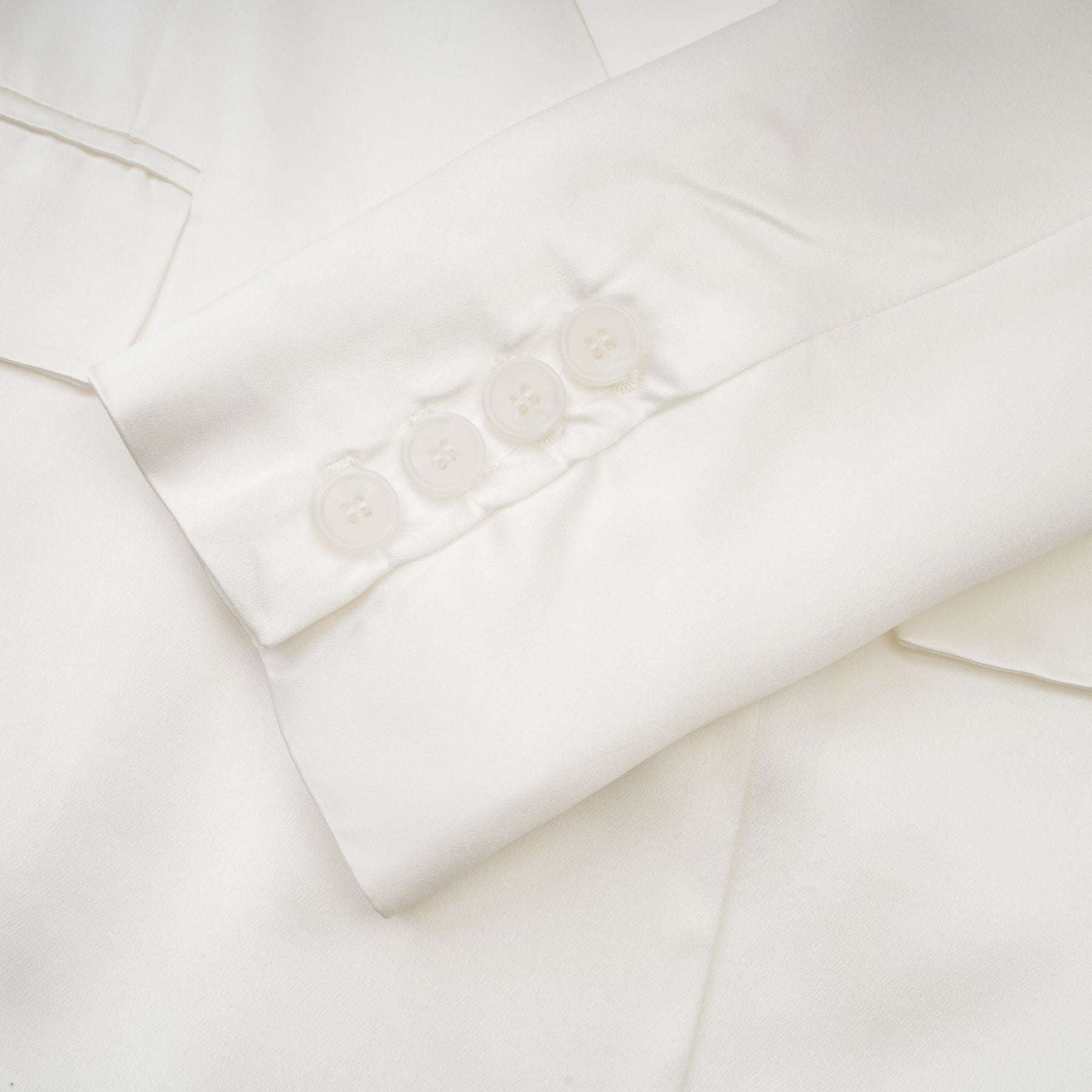 A white doublebreasted blazer named Sylvie worn by a model against a plain background