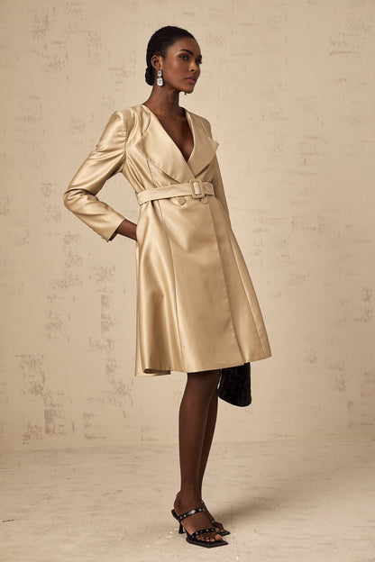 Woman wearing long khaki coat with belt at waist