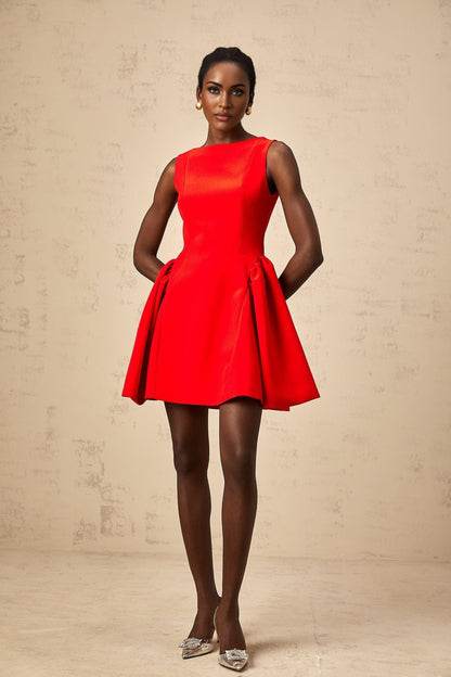 A woman wearing a vibrant red sleeveless mini dress with a flared skirt the dress has a fitted bodice and falls above the knee