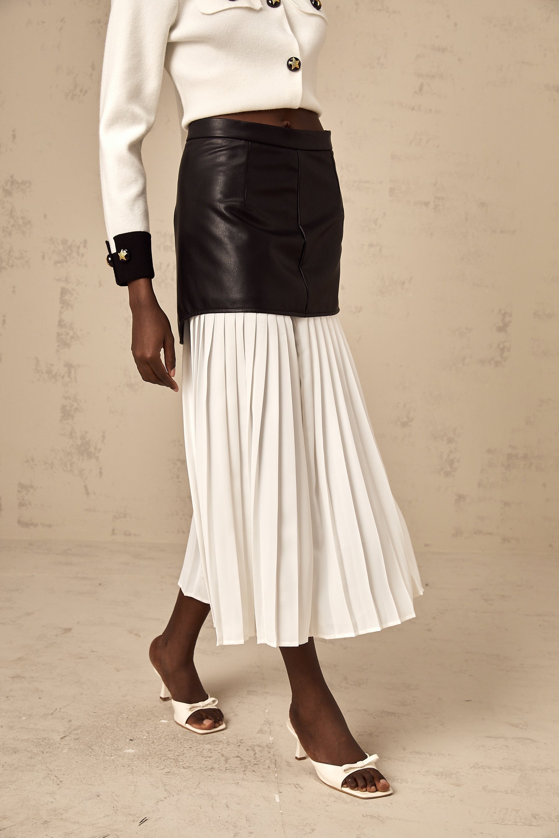 Woman wearing a midlength skirt with contrasting color panels and pleated design