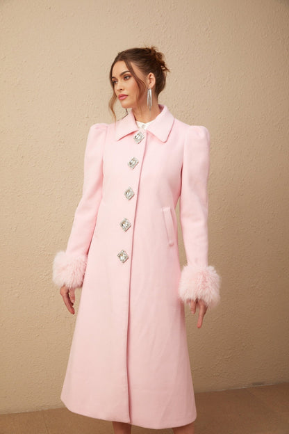 A pink faux fur overcoat named Louisette hanging on a clothing rack