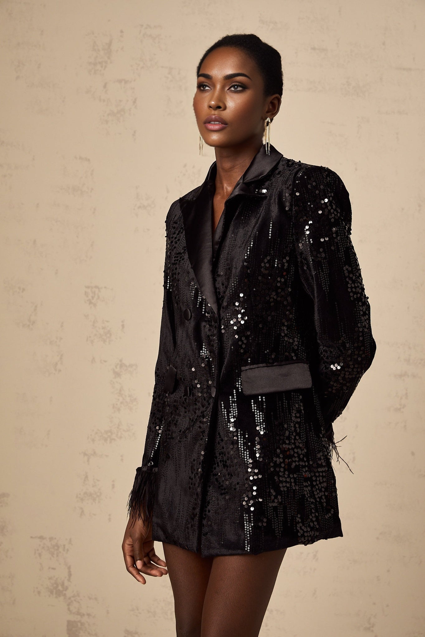 A black blazer with sequin embellishments and feather trim details along the edges named Ariane