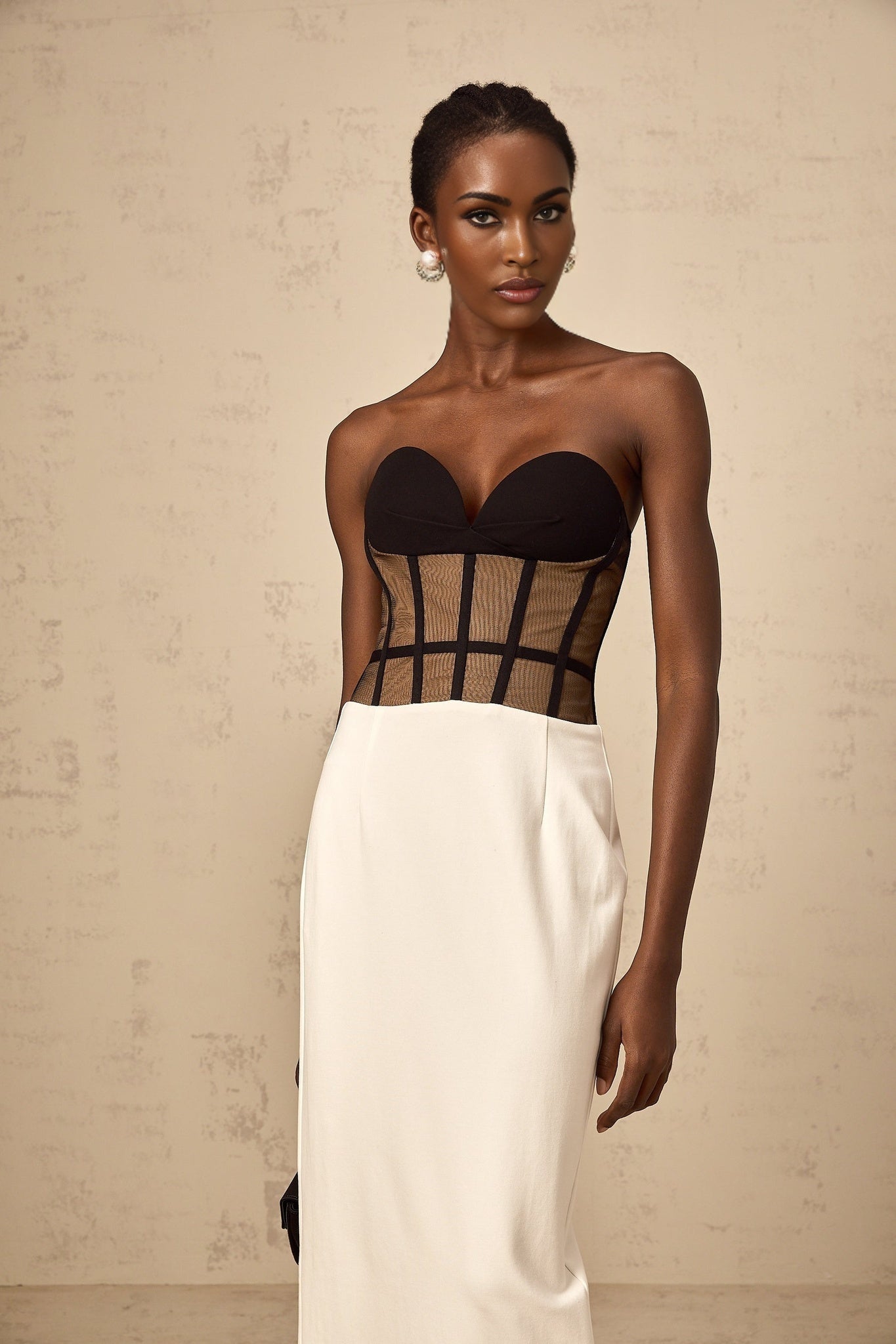 Woman wearing long sheer maxi dress with contrasting color corset bodice and flowing skirt