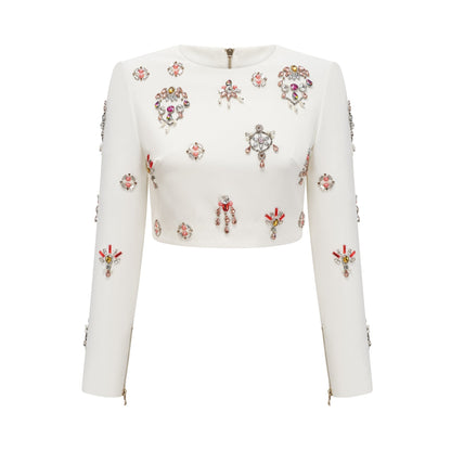 A white twopiece outfit consisting of a top and skirt adorned with crystal embellishments The set features a sleeveless top and a matching skirt both decorated with shimmering crystals in a delicate pattern The ensemble is named Jeanne and appears elegant and formal