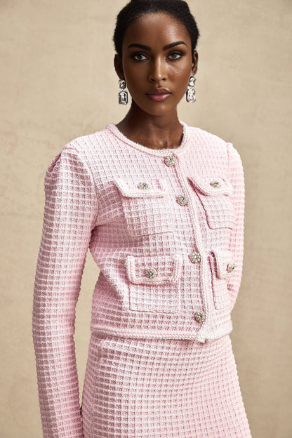 A pink waffle knit jacket and matching skirt set named Fabienne The outfit features a textured fabric and coordinated design for a cohesive look