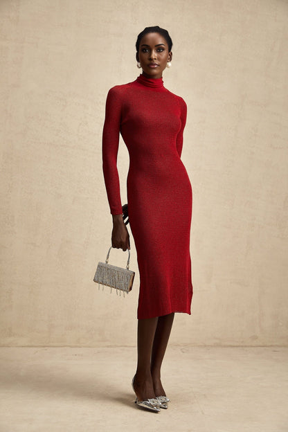 A woman wearing a red metallic midi dress with pointelle detailing standing against a plain background