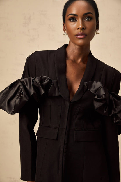 Woman wearing black fitted blazer with panelled design and boned structure