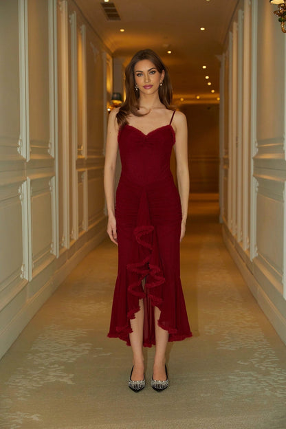 A long red maxi dress with ruffles and draped fabric detailing called the Viviane