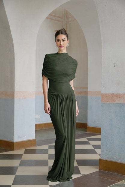A green asymmetric maxi dress with pleated details and a long flowing skirt worn by a model